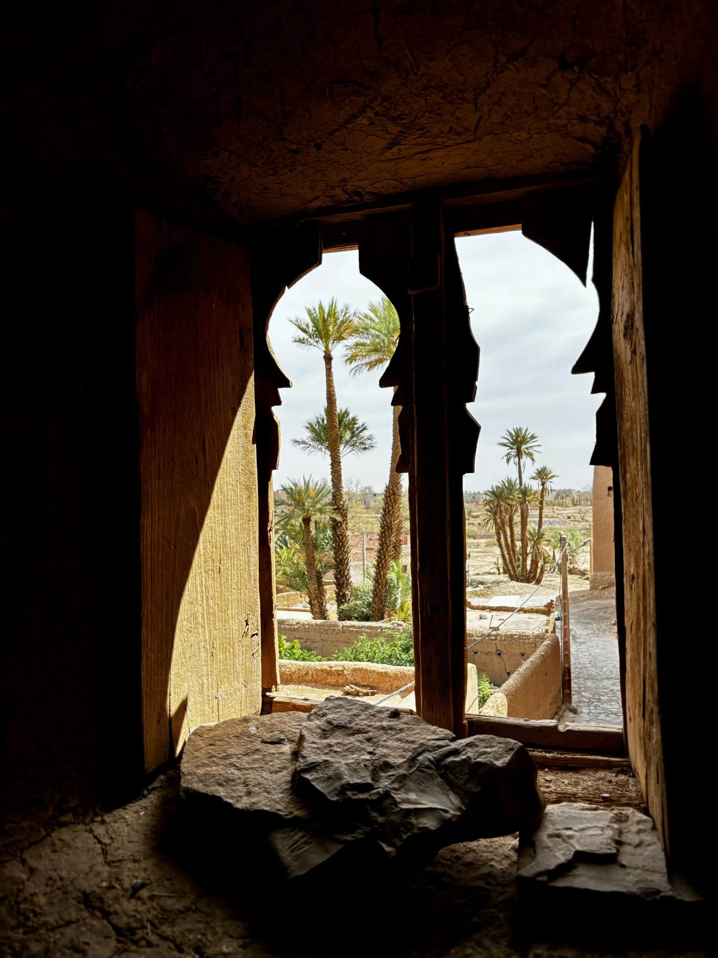 Warm Moroccan interior detail framing an oasis view